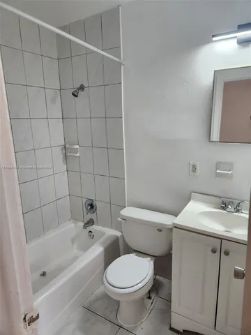 a white toilet sitting next to a bathroom sink and vanity