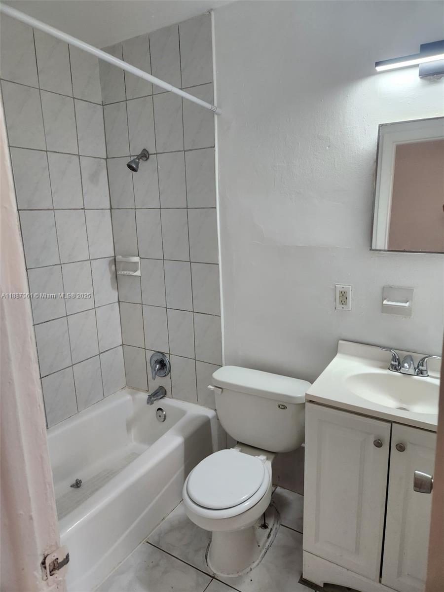 2640 Northwest 2nd Street, Unit 3 Pompano Beach, FL 33069 - Photo 8 of 9 a white toilet sitting next to a bathroom sink and vanity