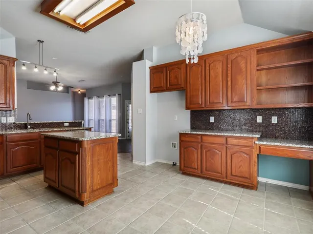 a large kitchen with stainless steel appliances granite countertop a sink dishwasher stove and cabinets