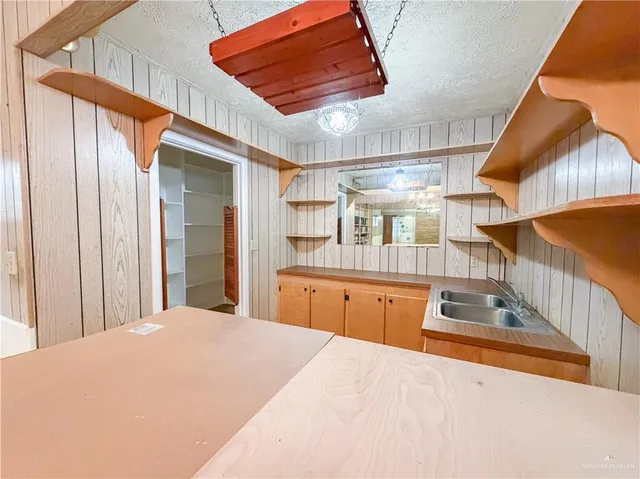 a kitchen with stainless steel appliances kitchen island a chandelier
