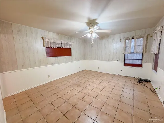 an empty room with windows and fan