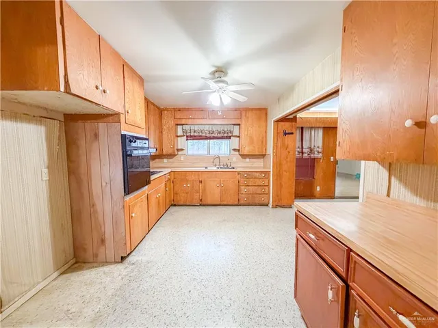 a kitchen with stainless steel appliances granite countertop a refrigerator a oven a sink with island and chairs