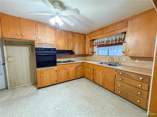 a kitchen with a sink a window and cabinets