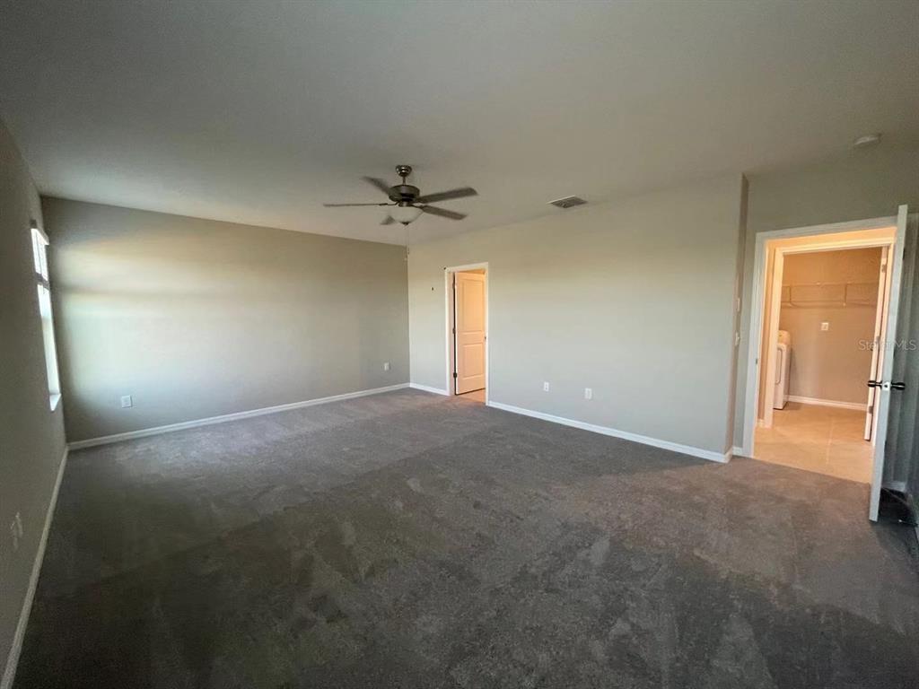31875 Sun Kettle Loop Wesley Chapel, FL 33545 - Photo 15 of 23 a view of an empty room with a chandelier fan