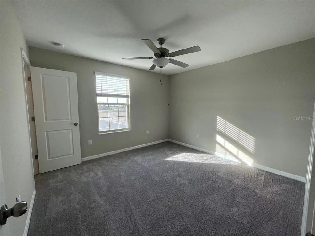 31875 Sun Kettle Loop Wesley Chapel, FL 33545 - Photo 16 of 23 an empty room with windows and fan