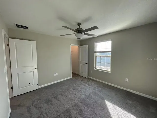 a view of a livingroom with a ceiling fan and window