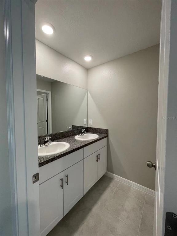 31875 Sun Kettle Loop Wesley Chapel, FL 33545 - Photo 19 of 23 a bathroom with a granite countertop sink and a mirror