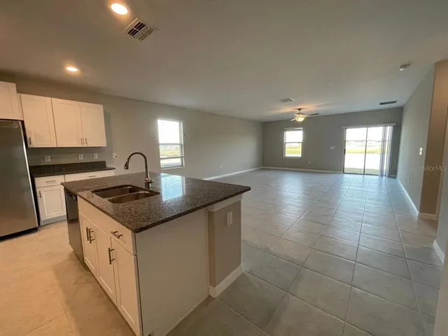 a kitchen with a sink a stove cabinets and stainless steel appliances