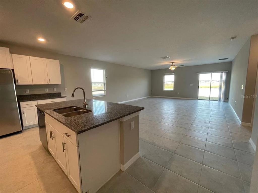 31875 Sun Kettle Loop Wesley Chapel, FL 33545 - Photo 7 of 23 a kitchen with a sink a stove cabinets and stainless steel appliances