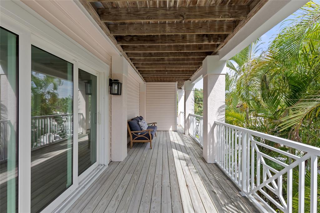 110 Spring Avenue Anna Maria, FL 34216 - Photo 24 of 62 a view of balcony with chairs and wooden floor