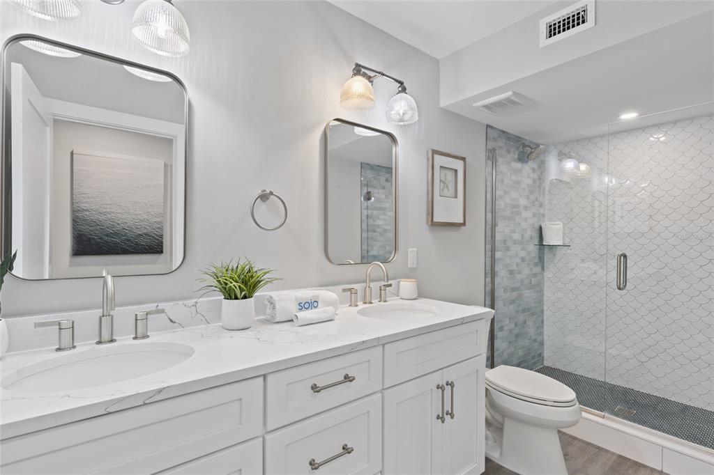 110 Spring Avenue Anna Maria, FL 34216 - Photo 25 of 62 a bathroom with a double vanity sink toilet mirror and shower
