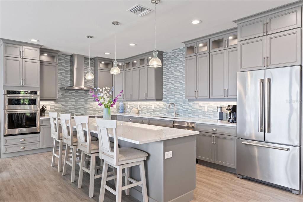110 Spring Avenue Anna Maria, FL 34216 - Photo 32 of 62 a kitchen with stainless steel appliances a dining table chairs sink and cabinets