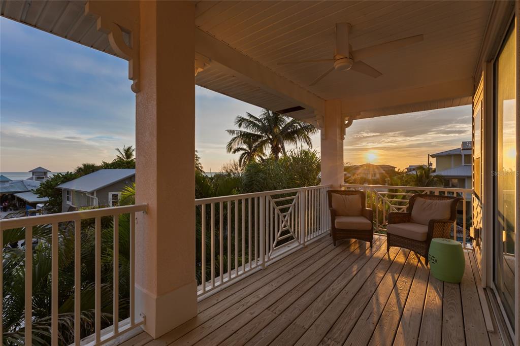 110 Spring Avenue Anna Maria, FL 34216 - Photo 48 of 62 a view of a balcony with chairs and wooden floor