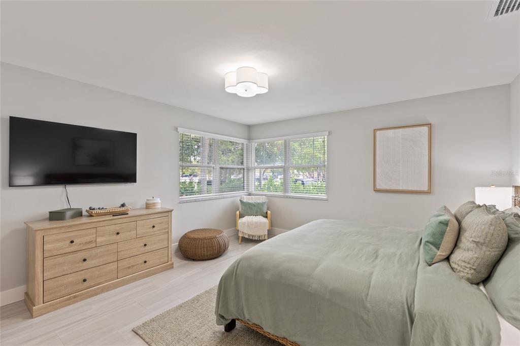 110 Spring Avenue Anna Maria, FL 34216 - Photo 6 of 62 a bedroom with two bed and a flat screen tv