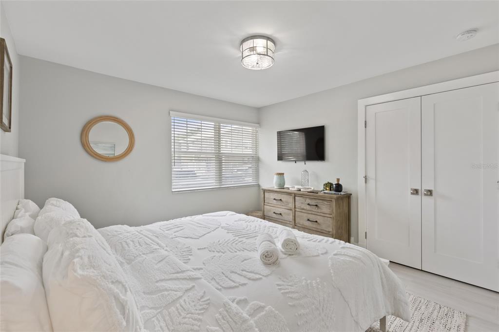 110 Spring Avenue Anna Maria, FL 34216 - Photo 10 of 62 a bedroom with a bed and a flat screen tv