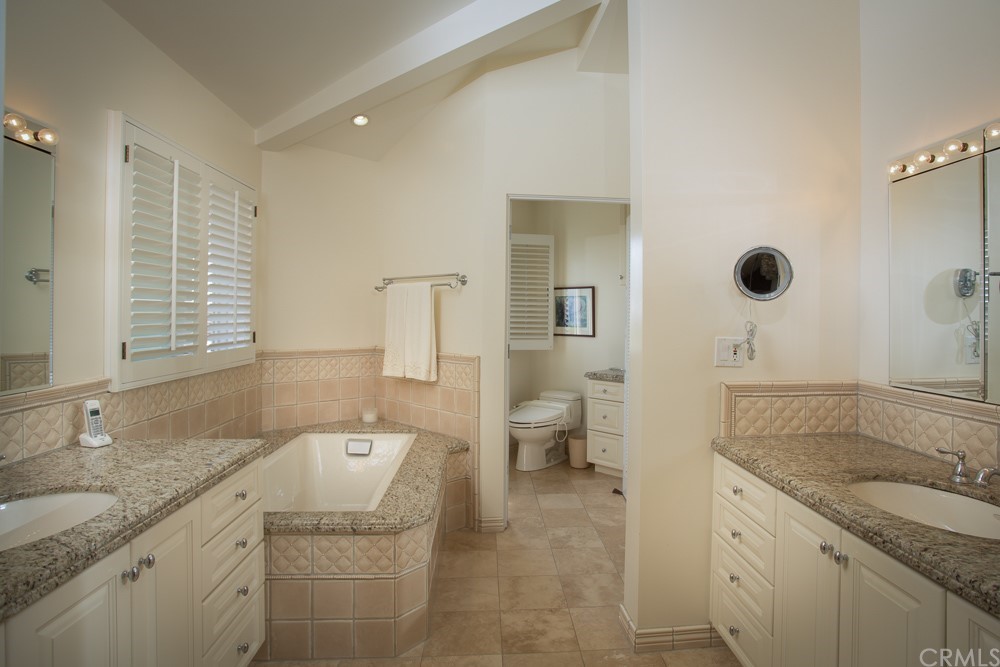 1004 Emerald Bay Laguna Beach, CA 92651 - Photo 11 of 15 a spacious bathroom with a granite countertop sink and a mirror