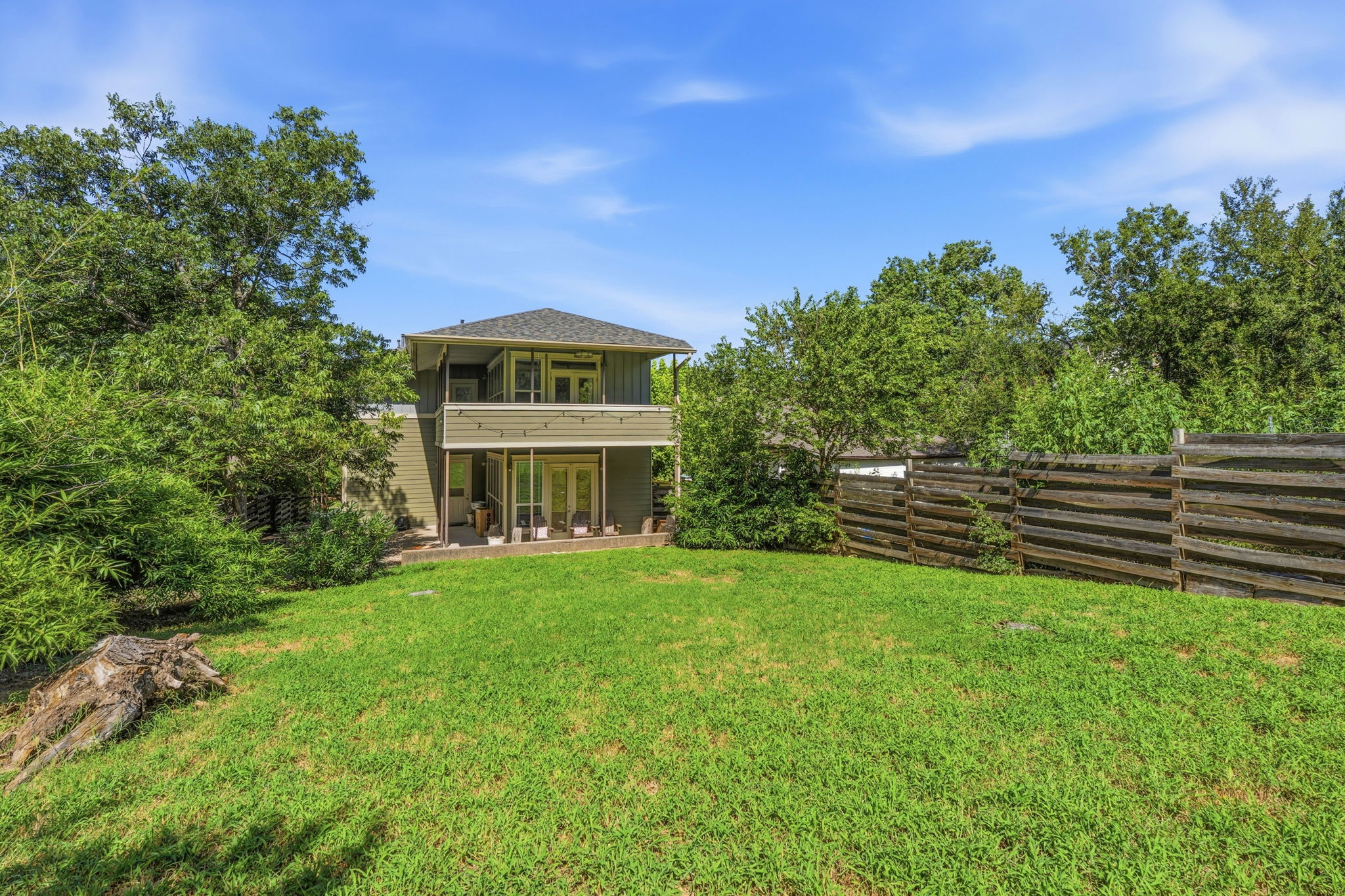 1305 Cometa Street Austin, TX 78721 - Photo 25 of 28 A spacious grassy yard provides ample outdoor living space, framed by a sturdy wooden fence.