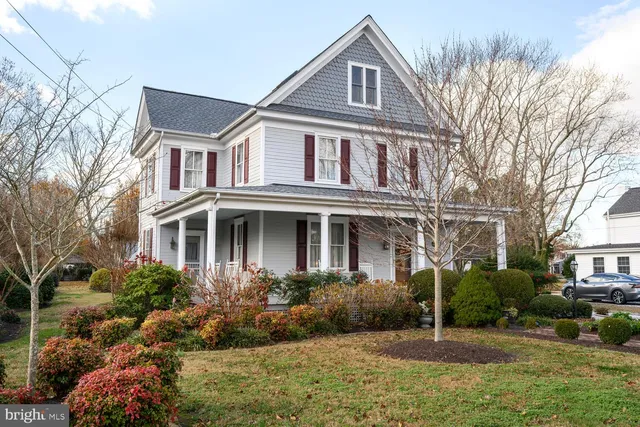 a front view of a house with a yard and potted plants