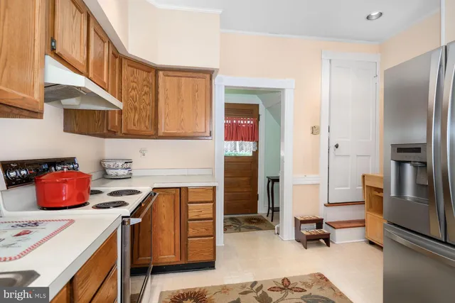 a view of a house with a yard covered with snow and trees