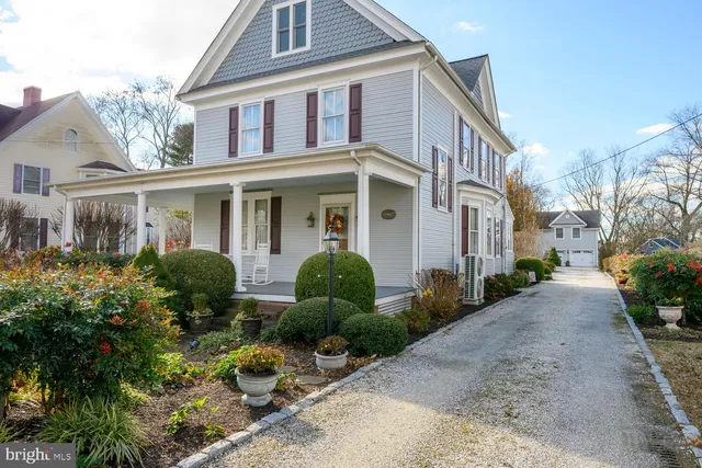 a front view of a house with garden and plants