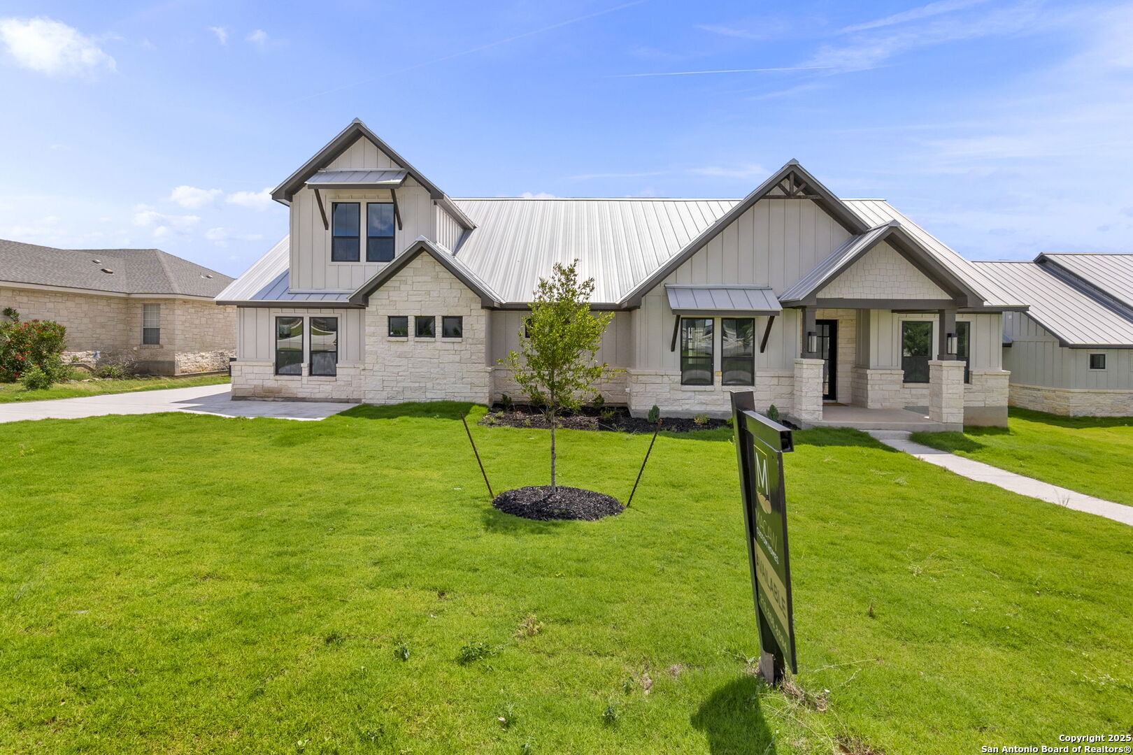 a front view of a house with a yard and trees