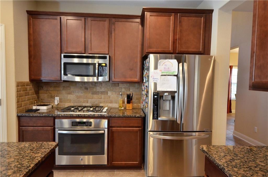 5629 Rio Chama Cove Austin, TX 78738 - Photo 10 of 34 Culinary delights await in this chef's kitchen, showcasing rich cabinetry and practical, durable countertops.