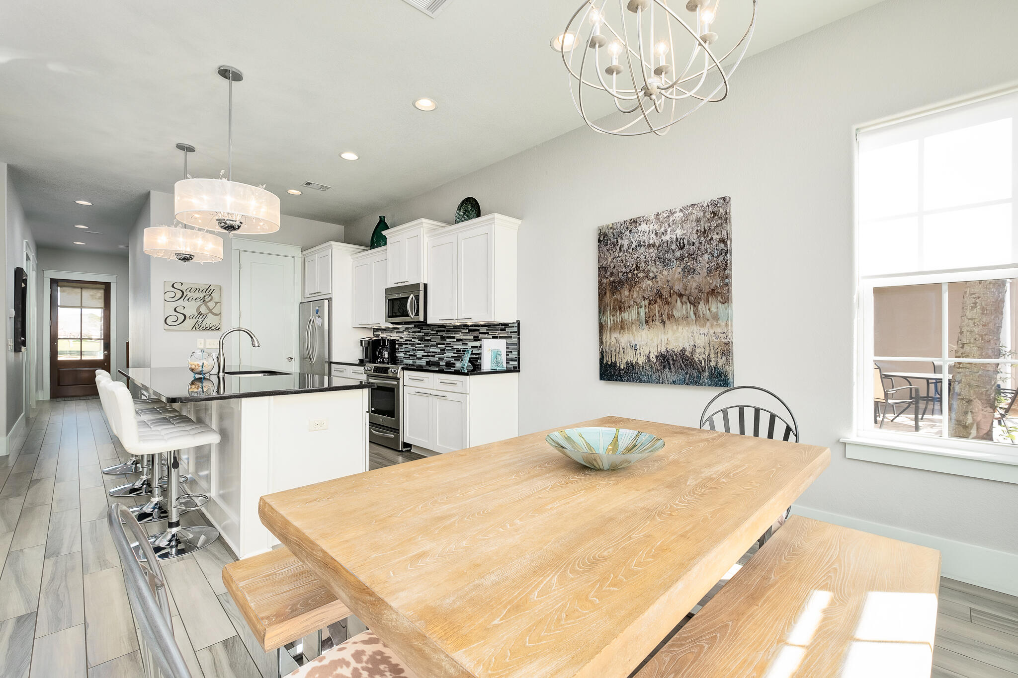 1959 Baytowne Loop Miramar Beach, FL 32550 - Photo 13 of 33 a kitchen with stainless steel appliances kitchen island granite countertop a stove a sink a dining table and chairs with wooden floor