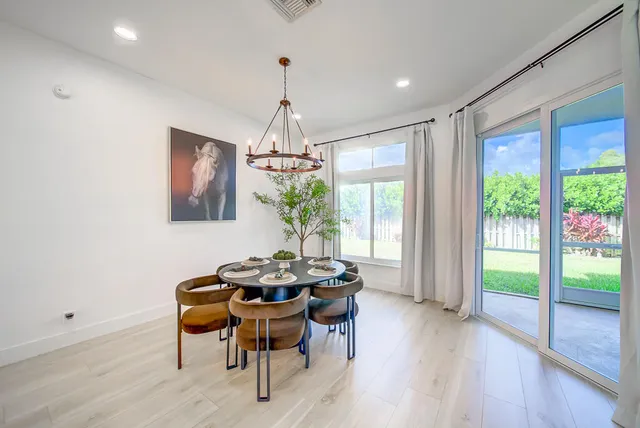 a dining room with furniture a chandelier and wooden floor
