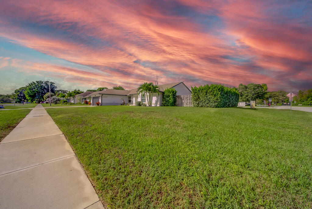 1853 Shower Tree Way Wellington, FL 33414 - Photo 5 of 31 a view of a garden with a building in the background