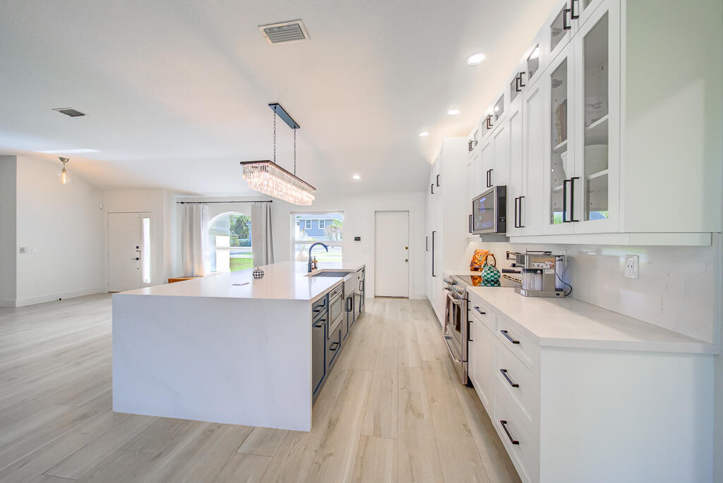 1853 Shower Tree Way Wellington, FL 33414 - Photo 8 of 31 a kitchen with kitchen island a sink stove and wooden cabinets