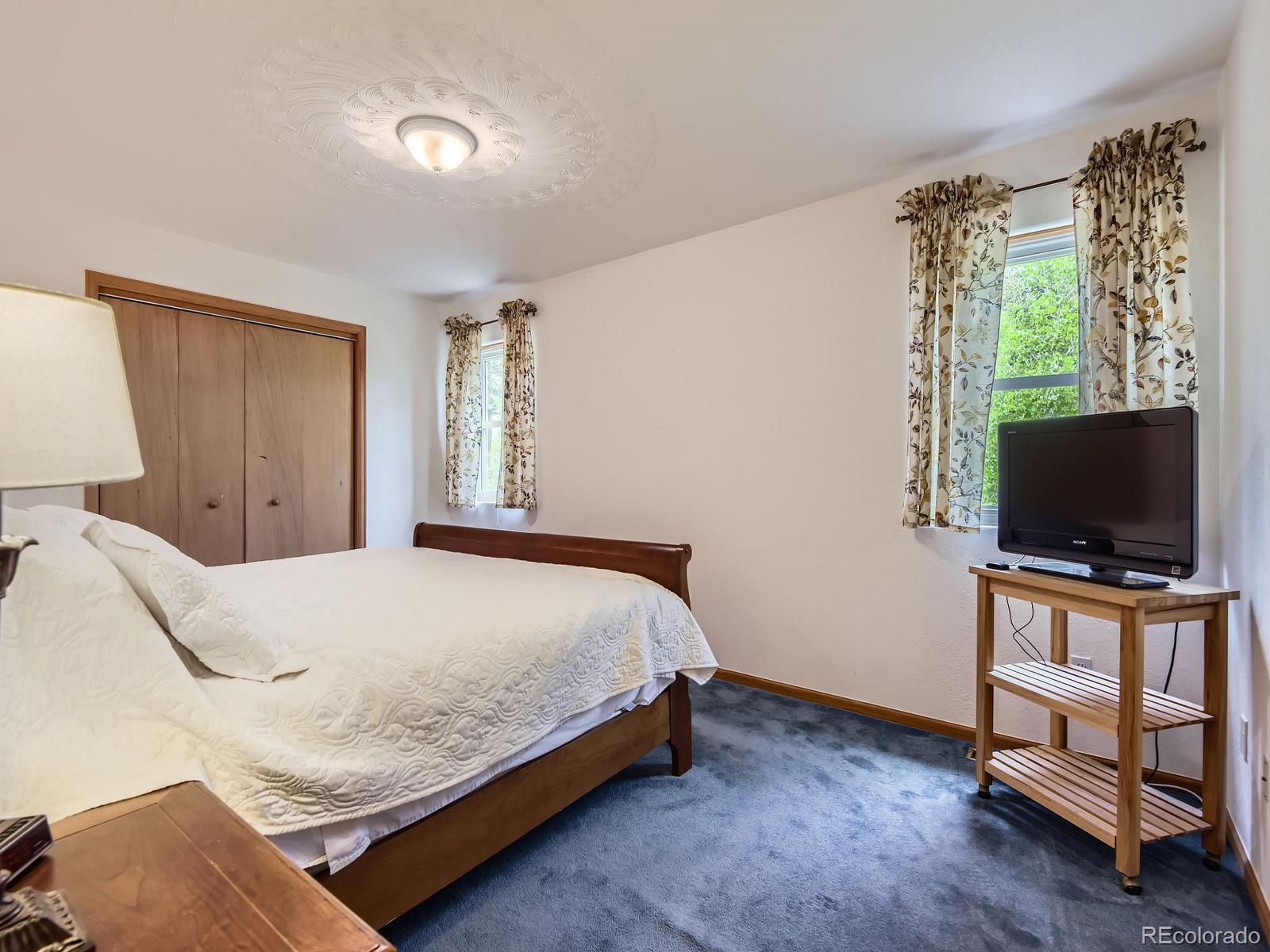 52 Branding Iron Lane Bailey, CO 80421 - Photo 19 of 29 a bedroom with a bed and a flat screen tv