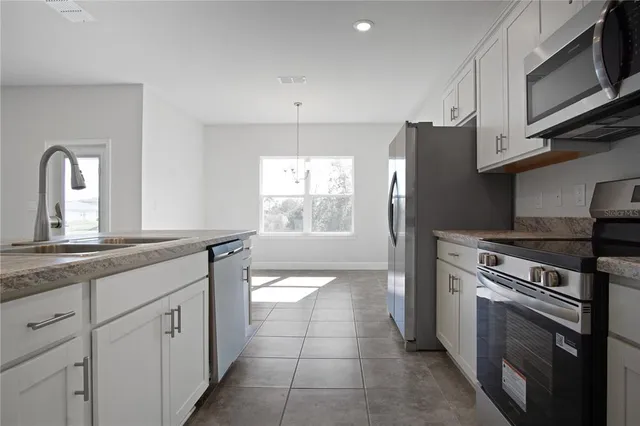 a kitchen with stainless steel appliances granite countertop a stove a sink and a refrigerator
