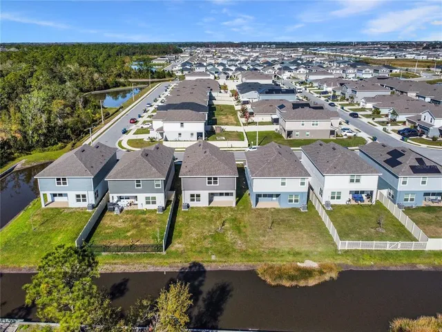 an aerial view of residential houses with outdoor space and swimming pool