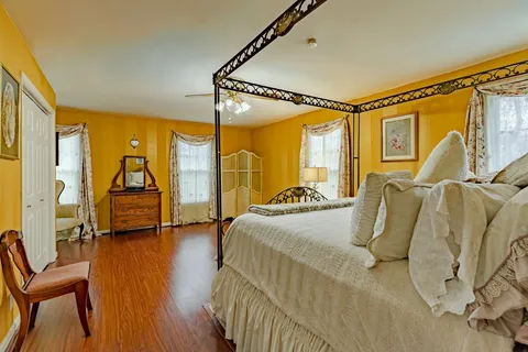 a bedroom with a bed and wooden floor