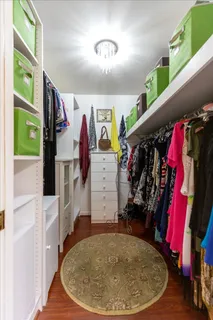 a view of walk in closet with clothes and shoes