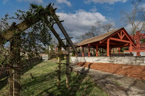a view of house with backyard and sitting area