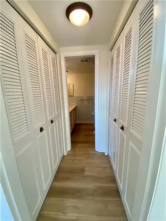 a view of a hallway with wooden floor and staircase