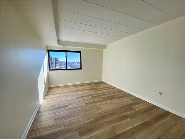 a view of a room with wooden floor and a window