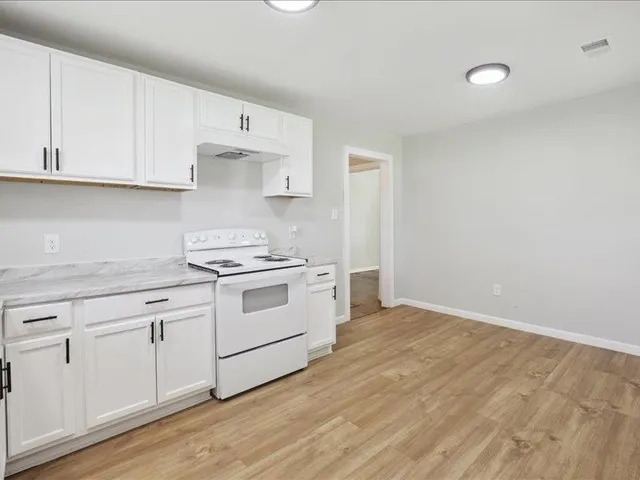 a kitchen with white cabinets and white appliances