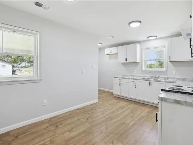 a kitchen with granite countertop white cabinets and white appliances