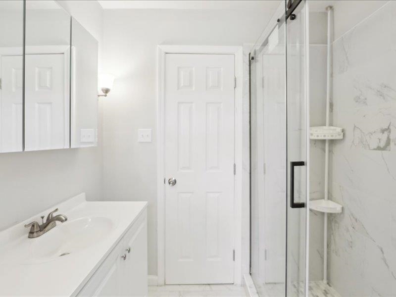 2725 Porter Road Mason, TN 38049 - Photo 19 of 33 a bathroom with a sink a mirror and shower