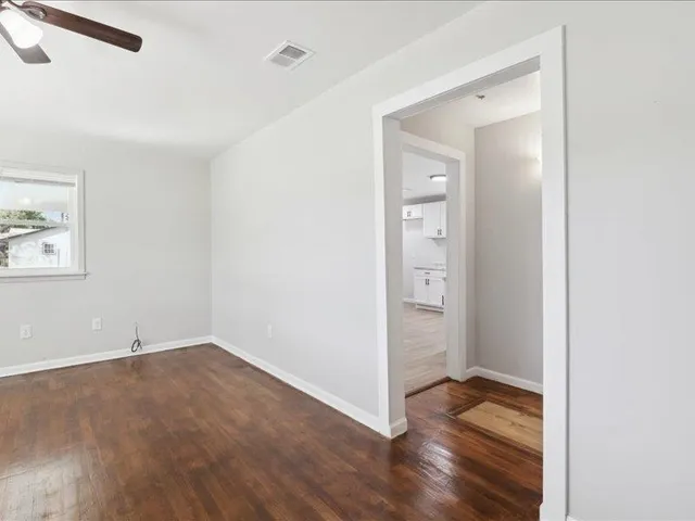 an empty room with wooden floor and closet