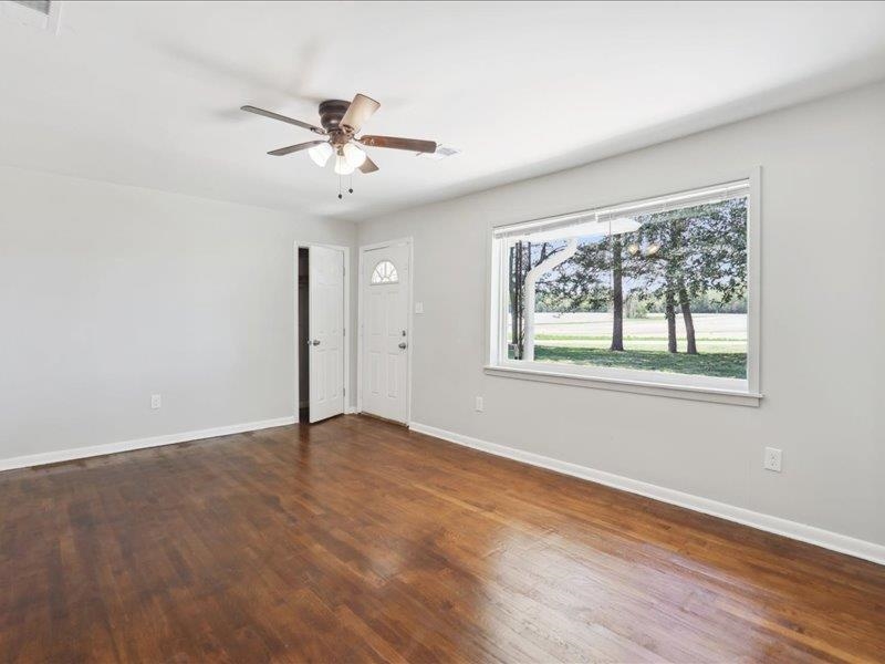 2725 Porter Road Mason, TN 38049 - Photo 7 of 33 an empty room with wooden floor chandelier fan and windows