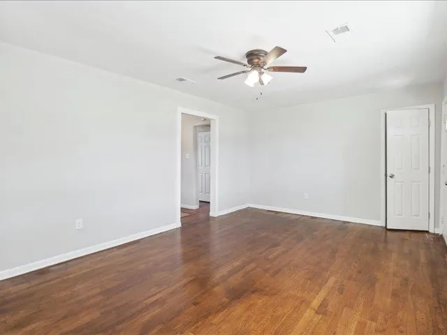a view of an empty room with wooden floor