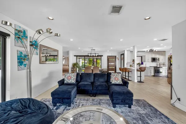 a kitchen with stainless steel appliances kitchen island granite countertop a refrigerator and a stove top oven with wooden floor