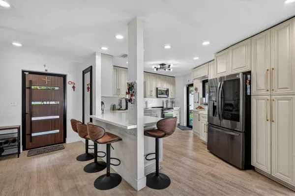 a large kitchen with stainless steel appliances lots of counter space sink refrigerator and cabinets