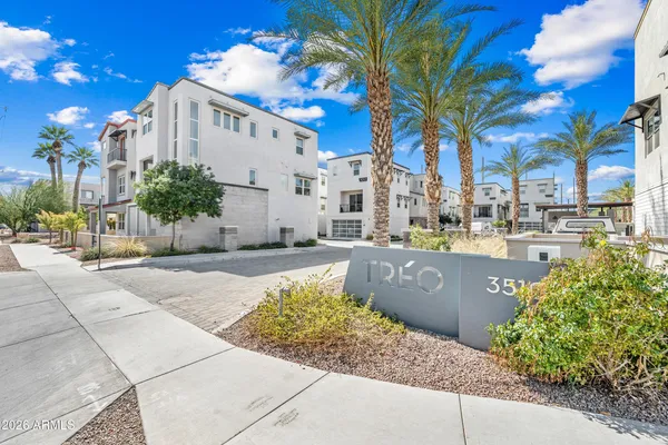 a view of a building with a yard and potted plants