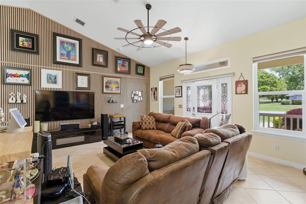 3510 Hunters Trail Circle Eustis, FL 32726 - Photo 11 of 26 a living room with furniture a flat screen tv and a large window