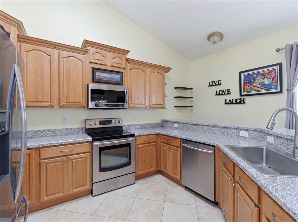 3510 Hunters Trail Circle Eustis, FL 32726 - Photo 8 of 26 a kitchen with stainless steel appliances granite countertop a sink stove and microwave