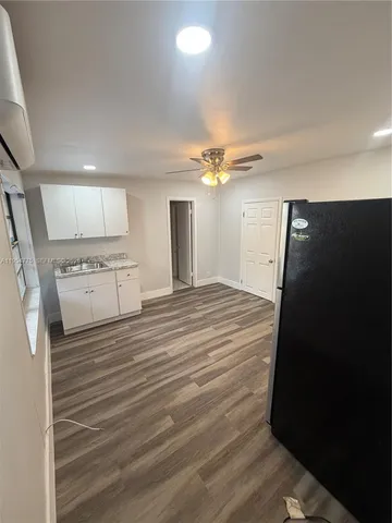 a view of a kitchen with a refrigerator cabinets and a ceiling fan